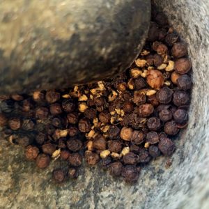 poivre en grains dans un pilon